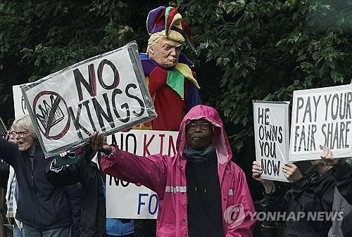 트럼프 밈코인 행사에 항의하는 시위대 (미국 버지니아주 스털링 로이터=연합뉴스) 2025년 5월 22일 미국 버지니아주 스털링의 트럼프 내셔널 골프 클럽 입구에서 시위대가 시위를 벌이고 있다. (REUTERS/Ken Cedeno) 2025.5.24.