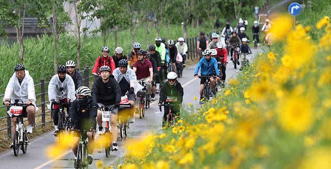▲ 챌린지 코스에 참가한 라이더들이 남한강변에 핀 국화 사이를 힘차게 달리고 있다.