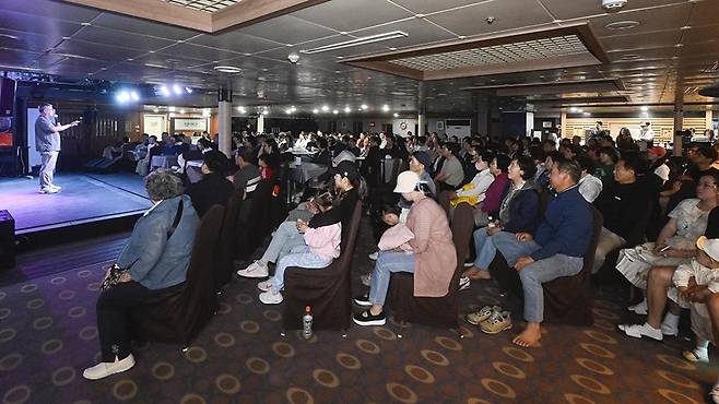 전국 최초 섬 크루즈 여행 상품인 ‘전남 섬 밤바다 크루즈’가 지난 23일 여수엑스포여객선터미널에서 첫 시범 운항에 나섰다. 사진은 운항에 투입된 팬스타드림호와 선내에서 공연 중인 모습. /김애리 기자·조영권 인턴 기자