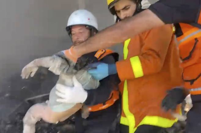 23일(현지시간) 가자지구 칸유니스에서 벌어진 이스라엘군 공습으로 숨진 아이를 구조대가 옮기고 있다. 나세르 병원 의사 알라 알 나자르의 9명 자녀 중 한 명으로, 나자라는 10명 자녀 중 9명을 잃었다. AP연합뉴스