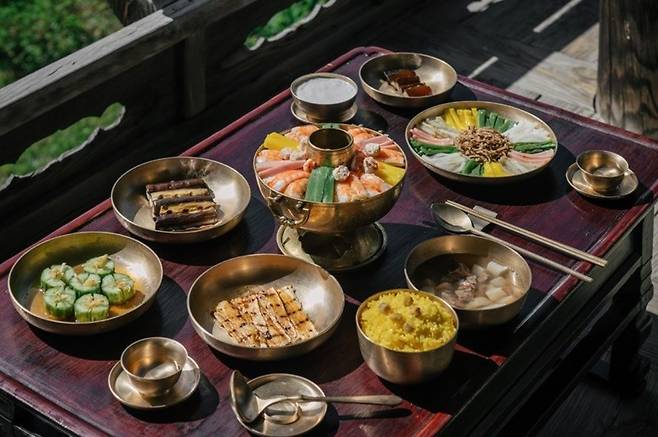 An Andong-style meal features a tricolor soup made with sweetfish, shrimp and mung bean jelly and "hyanggwajeo," pickled cucumbers decorated with finely sliced ginger. (Korean Food Promotion Institute)