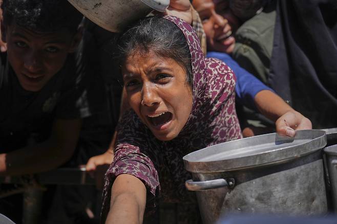 23일 팔레스타인 가자지구에서 한 여성이 구호 물품을 받기 위해 울부짖고 있다. AP연합뉴스