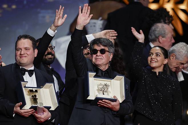 영화 '단순한 사고'로 제78회 칸영화제 황금종려상을 수상한 이란 감독 자파르 파나히(가운데)가 시상식에서 환호에 답하는 모습. 로이터연합뉴스