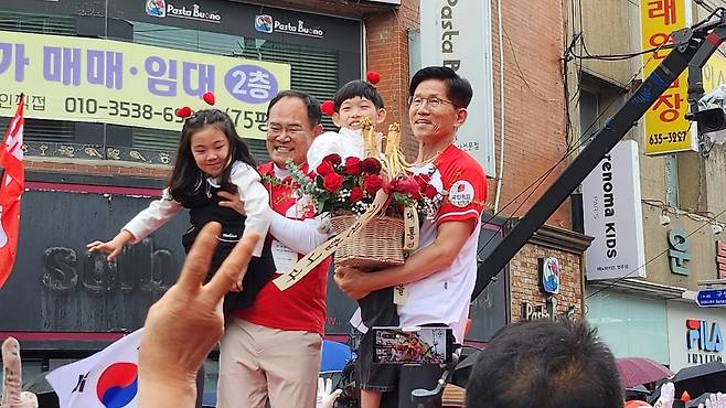 김문수 국민의힘 대선 후보가 24일 오후 경북 영주시 태극당 앞 유세현장에서 임종득 의원과 함께 어린이로부터 꽃다발을 선물받고  기념사진을 찍고 있다(사진=김성권 기자)