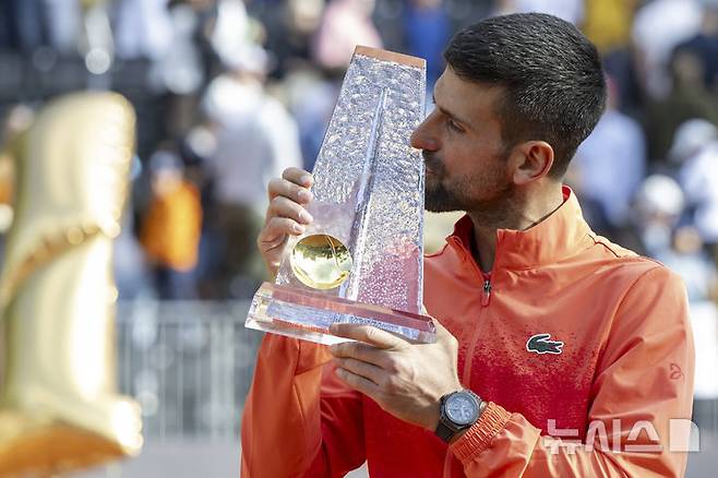 [제네바=AP/뉴시스] 노바크 조코비치(6위·세르비아)가 24일(현지 시간) 스위스 제네바에서 열린 남자프로테니스(ATP) 투어 제네바 오픈(ATP250) 정상에 올라 트로피를 들고 입 맞추고 있다. 조코비치는 단식 결승에서 후베르트 후르카치(31위·폴란드)에게 힘겹게 2-1(5-7 7-6 7-6) 역전승을 거두고 우승하며 ATP 투어 이상급 대회 단식 100회 우승의 대기록을 작성했다. 2025.05.25.