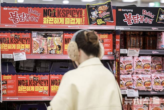 [서울=뉴시스] 서울시 내 대형마트를 찾은 여행객이 K-푸드로 인기를 끌고있는 불닭볶음면을 살펴보고 있다. photo@newsis.com
