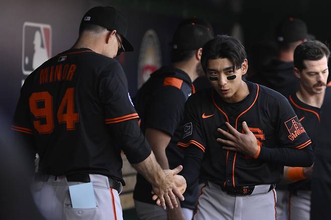 ▲ 더그아웃에서 데몬 마이너 코치와 악수하는 이정후 ⓒ연합뉴스/AP