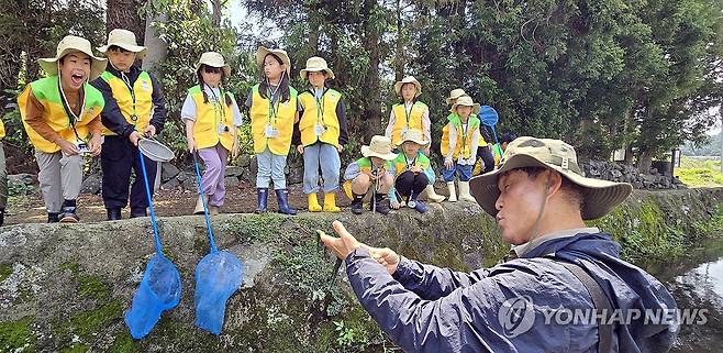 마르형 습지 '하논'의 수생식물 설명하는 김찬수 소장 (서귀포=연합뉴스) 김호천 기자 = 람사르습지도시 어린이 습지탐사대 1기 학생들이 25일 오전 서귀포시에 있는 국내 최대 마르형 분화구인 '하논'을 탐사한 가운데 김찬수 사단법인 한라산생태문화연구소 소장이 수생식물을 채취해 보여주며 설명하고 있다. 2025.5.25 khc@yna.co.kr