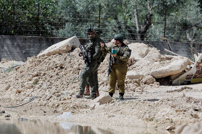 Is“이스라엘 병사들이 팔레스타인 사람들이 짐을 챙기기 위해 툴카름 난민촌에 들어가는 것을 막으며 서 있다. (사진=로이터)