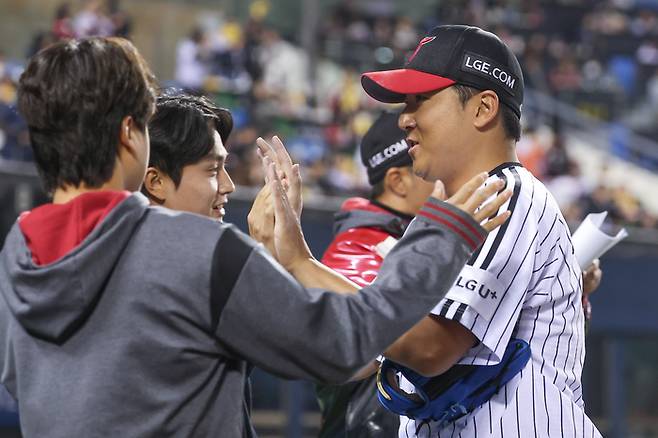 LG 송승기가 27일 잠실구장에서 열린 자신의 데뷔 첫 1군 등판 경기 한화전을 마치고 더그아웃에 들어가며 동료들과 하이파이브 하고 있다.  사진 | 연합뉴스