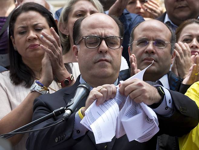 2017년 3월 30일 훌리오 보르헤스 베네수엘라 국회의장이 사법부가 입법권을 대행하도록 판결한 대법원 판결문을 찢어버리고 있다. 베네수엘라는 이날 대법원의 판결로 집권세력에 유일하게 반대 목소리를 내왔던 의회의 입법권을 빼앗아 삼권분립의 원칙마저 붕괴됐다./AP 연합뉴스