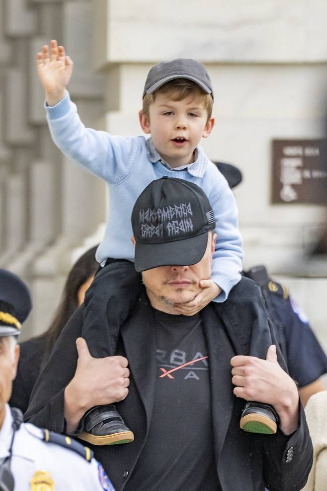 일론 머스크가 지난 21일(현지시간) 미국 워싱턴DC 연방 의회 의사당에서 상원 상업과학교통위원회 위원들과 만난후 아들 X와 함께 떠나고 있다.UPI연합뉴스