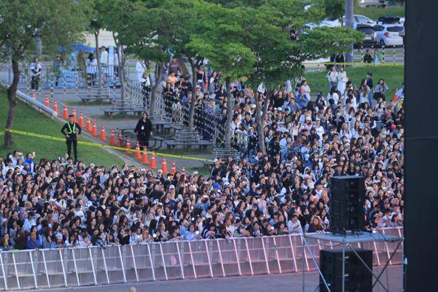 25일 서울 반포한강공원에서 그룹 세븐틴의 팬과 시민들이 세븐틴 데뷔 10주년 기념 공연을 생중계되는 영상으로 관람하고 있다. 연합뉴스