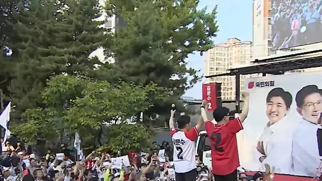 김문수·한동훈 두 인물이 유세 무대 위에 함께 선 가운데, 수많은 지지 인파가 어우러져 ‘공식 연대’를 보여주고 있다. (유튜브 캡처)