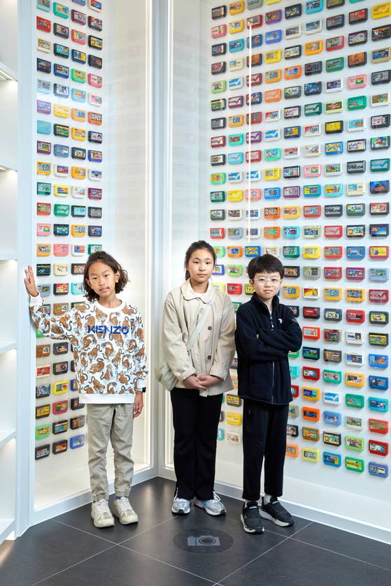 이성빈·정서우·최수혁(왼쪽부터) 학생기자가 '패밀리컴퓨터롬팩' 앞에서 사진을 촬영했다. 롬팩은 1980~90년대 게임을 할 때 사용한 플라스틱 패키지다.