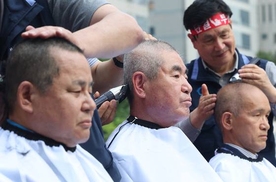 전국자동차노련 서울시버스노조 교섭위원들이 26일 서울 송파구 서울시교통회관에서 열린 파업 출정식에서 삭발하고 있다. [연합뉴스]