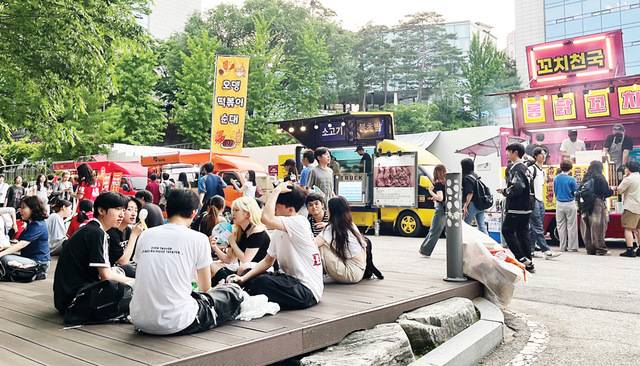 지난 21일 서울 시내 한 대학 축제 현장에는 다양한 푸드트럭이 즐비한 가운데 학생들이 야외에 삼삼오오 모여 음식을 즐기고 있다.