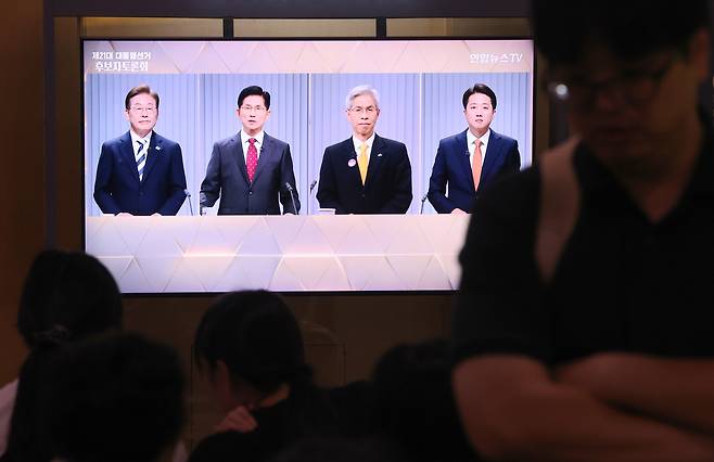 지난 23일 서울역 대합실에서 시민들이 제21대 대통령선거 2차 후보자 토론회 중계방송을 시청하고 있다. [연합]