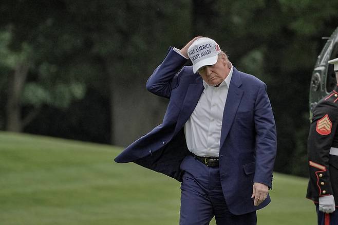 도널드 트럼프 미국 대통령이 25일(현지시간) 워싱턴 D.C. 백악관 남쪽 잔디밭을 걸으며 모자를 들고 있다. [로이터]