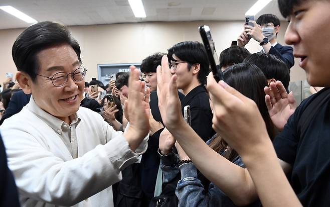 이재명(왼쪽) 더불어민주당 대선후보가 26일 오전 경기 수원시 영통구 월드컵로 아주대학교에서 열린 ‘아주대와 함께하는 대학생 간담회’를 마친 뒤 학교를 떠나며 학생들과 하이파이브를 하며 인사하고 있다. 수원=임세준 기자