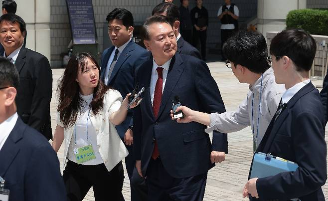 윤석열 전 대통령이 26일 서울 서초구 서울중앙지방법원에서 열린 내란 우두머리 혐의ㆍ직권남용 권리행사 방해 혐의 사건 5차 오전 공판을 마친 뒤 지지자들을 바라보며 차량으로 향하고 있다. 연합뉴스