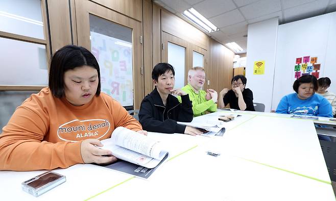 지난달 16일 서울 영등포구 발달장애인 지원단체 피플퍼스트에서 서울센터 소속 박경인·소형민·문석영·박현철·김현아씨(왼쪽부터)가 지난 20대 대통령선거 때 나온 선거 공약서를 읽고 있다. 남정탁 기자