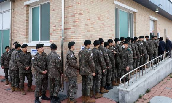 투표를 명 받았습니다 - 제22대 국회의원선거 사전투표 첫날인 5일 오전 강원 춘천시 신북읍 주민자치센터에 마련된 사전투표소에서 군 장병이 투표를 위해 길게 줄을 서 있다. 2024.4.4 / 연합뉴스