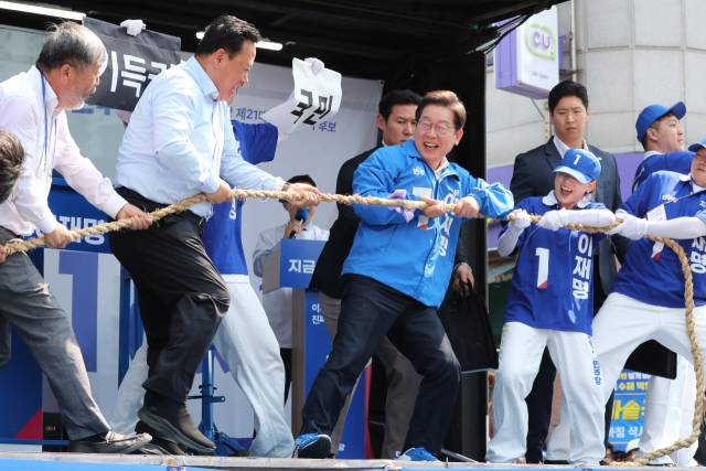 이재명 더불어민주당 대선 후보가 25일 충남 당진시 당진전통시장에서 연설에 앞서 줄다리기 퍼포먼스를 하고 있다. 당진=오승현 기자