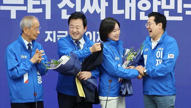 더불어민주당의 박찬대 대표 직무대행 겸 원내대표(맨 오른쪽)와 윤여준 총괄선대위원장(맨 왼쪽)이 26일 서울 여의도 민주당사에서 열린 중앙선거대책위원회의에서 허은아(오른쪽 두번째) 전 대표, 김용남 전 의원에게 선거운동복을 입혀 준 뒤 손잡고 있다. ⓒ연합뉴스