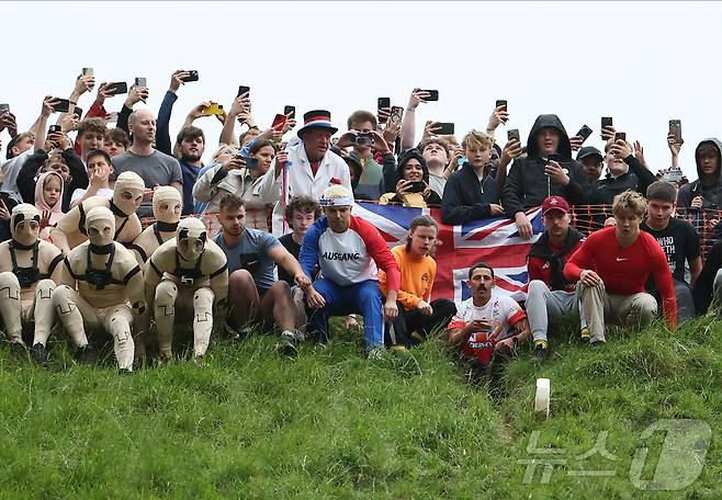 26일(현지시간) 영국 브록웍스의 쿠퍼스 힐에서 열린 '구르는 치즈 잡기' 대회에서 참가자들이 치즈를 쫒아 언덕을 내려가고 있다. ⓒ 로이터=뉴스1