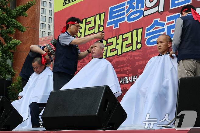 26일 서울 송파구 교통회관 앞에서 열린 서울시버스노조 총파업 투쟁 승리쟁취 버스노동자 결의대회에서 교섭위원들이 삭발식을 하고 있다. /뉴스1