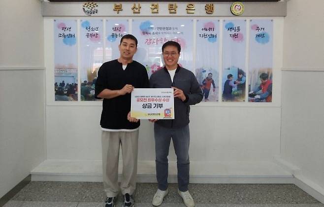 문현역 남재우 과장이 수상 상금을 부산연탄은행에 기부하고 있다.(왼쪽 남재우 과장) 부산교통공사 제공