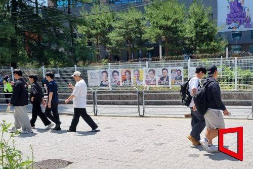 대전 충남대 앞에 붙은 21대 대선 후보들 홍보 포스터 앞을 학생들이 무심히 지나가고 있다. 대전=문혜원 기자