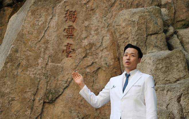 정형외과 의사인 배승호 역곡서울성모정형외과의원 원장이 서울 종로구 한 학교 구내에서 바위에 새겨진 ‘弼雲臺(필운대)’ 글씨를 설명하고 있다. 배 원장은 전국 ‘바위 글씨’의 답사기인 ‘어쩐지 나만 알 것 같은 역사’를 냈다./장경식 기자