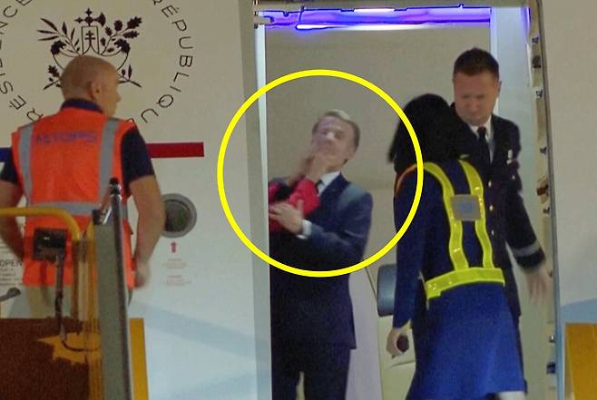 25일  베트남을 방문하기 위해  하노이 공항에 도착한 에마뉘에 마크롱 프랑스 대통령이 전용기에서 내리기전 부인 브리지트 마크롱 여사에게 손으로 얼굴을 맞고 있다. /AP 연합뉴스