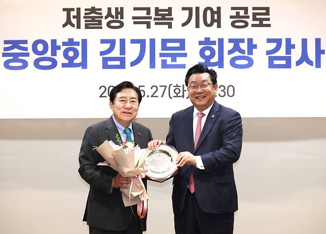 김기문 중소기업중앙회장(왼쪽)이 저출산고령사회위원회로부터 중소기업의 일·가정 양립 문화를 확산시키기 위해 노력한 공로로 감사패를 받았다. 김기문 중앙회장과 주형환 저출산고령사회위원회 부위원장(오른쪽)이 감사패 수여식에서 기념 촬영했다.(사진=중소기업중앙회)