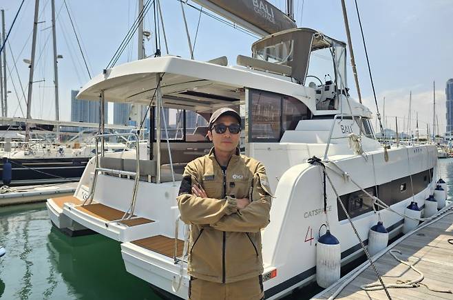 27일 부산 수영만 요트경기장에서 만난 김건우 요트탈래 대표. 본지와 인터뷰 후 요트탈래의 선박 앞에서 포즈를 취하고 있다. 사진=변옥환 기자