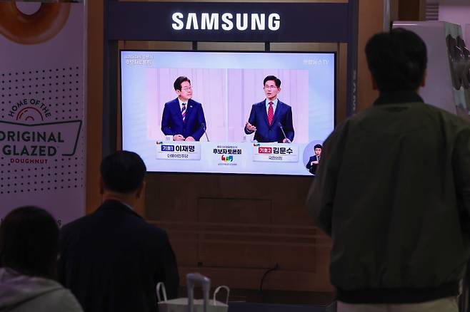 제21대 대통령선거 후보 정치분야 TV토론회가 열린 27일 서울역 대합실에서 시민들이 토론회 중계방송을 지켜보고 있다. 연합뉴스