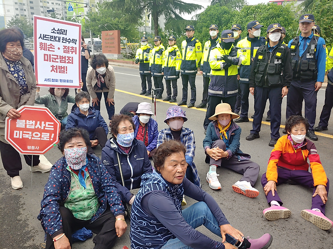 6개 시민·사회·종교 단체로 구성된 사드철회평화회의 회원들이 15일 경북 칠곡군에 있는 주한미군 캠프캐롤 앞에서 ‘소성리 사드반대 현수막 훼손·절취 미군 범죄 규탄’ 기자회견을 열고 앉아 있다. 사드철회평화회의 제공