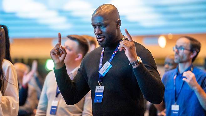 행사 참여자가 2022년 독일 뒤셀도르프에서 열린 전도 정상회담에 참석해 두 손을 높이 들고 있다. BGEA 홈페이지