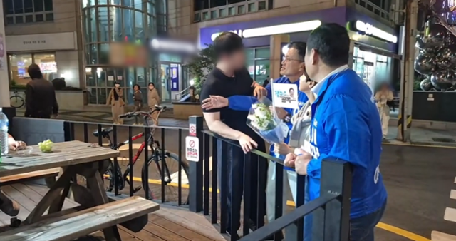 박주민 더불어민주당 의원에게  검은색 상의를 입은 남성(왼쪽)이 다가가 대화를 시도하고 있다. [사진 출처 = 박주민 의원 유튜브 채널 영상 갈무리]