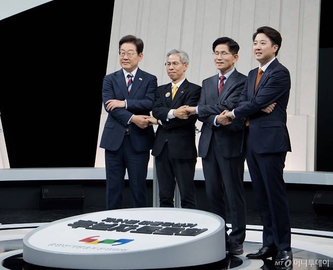 [서울=뉴시스] 국회사진기자단 = 27일 오후 서울 마포구 상암동 MBC 스튜디오에서 열린 중앙선거방송토론위원회 주관 제21대 대통령선거 3차 후보자토론회 시작에 앞서 각 정당 대선후보들이 기념촬영을 하고 있다. 왼쪽부터 이재명 더불어민주당, 권영국 민주노동당, 김문수 국민의힘, 이준석 개혁신당 대선후보. 2025.05.27. photo@newsis.com /사진=