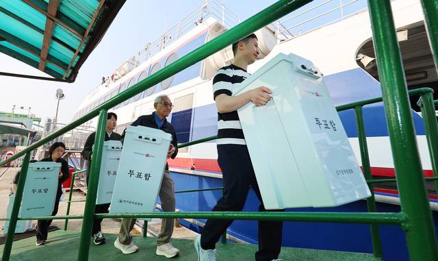 섬으로 향하는 투표함 제21대 대통령 선거를 일주일 앞둔 27일 오전 인천 중구 인천항 연안여객터미널에서 옹진군 선거관리위원회 관계자들이 연평·덕적도 등 섬 지역 투표소에 보낼 투표함을 들고 여객선에 오르고 있다. 연합뉴스