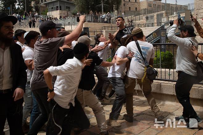 [ 예루살렘=신화/뉴시스] 5월 26일 국기행진 도중 동예루살렘에 침입한 유대인 극우파 청년들이 항의하는 팔레스타인 남성을 공격하고 있다. 2025. 05. 27.