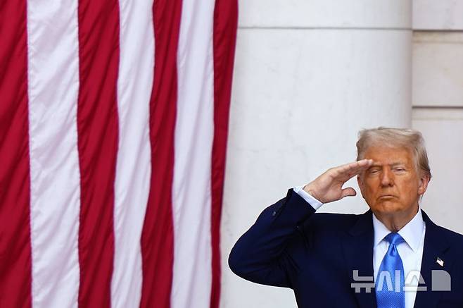 [알링턴=AP/뉴시스] 도널드 트럼프 미국 대통령이 26일(현지 시간) 버지니아주 알링턴 국립묘지에서 열린 제157회 메모리얼 데이(현충일) 추념식에 참석해 거수경례하고 있다. 트럼프 대통령은 "미국이 존재할 수 있는 것은 국가가 부를 때 주저하지 않고 모든 것을 바쳐 헌신한 이들 덕분"이라며 전몰장병들을 추모했다. 2025.05.27.