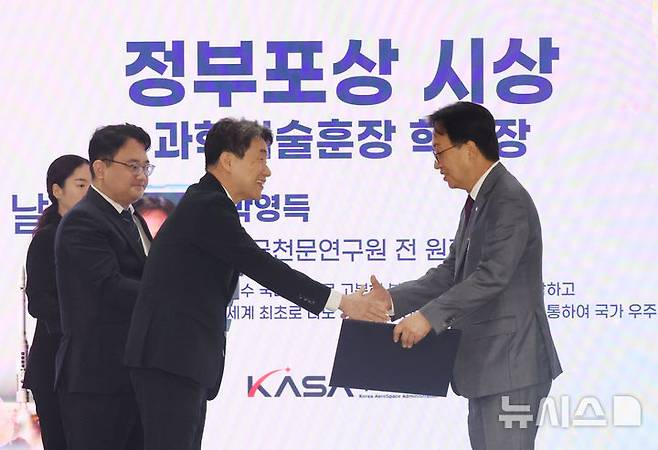 [사천=뉴시스] 최진석 기자 = 이주호 대통령 권한대행 부총리 겸 교육부 장관이 27일 경남 사천 우주항공청에서 열린 제1회 우주항공의 날 기념식에서 박영득 전 한국천문연구원장에게 과학기술훈장 혁신장을 수여하고 있다.  (대통령실통신사진기자단) 2025.05.27. myjs@newsis.com