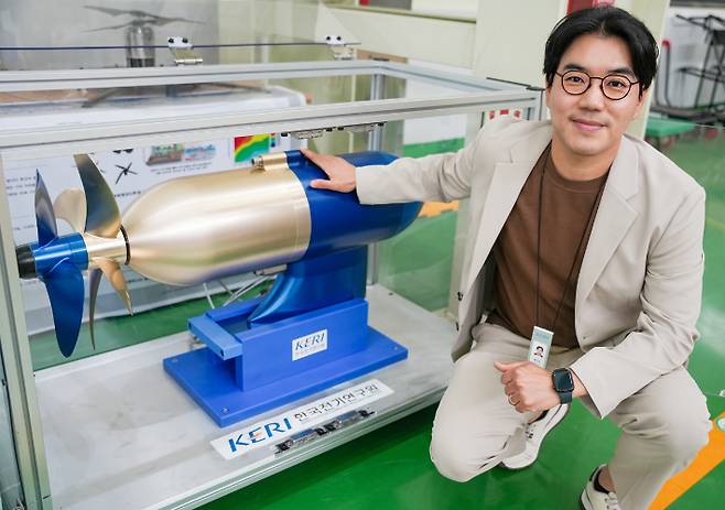 KERI 홍도관 박사가 '50kW급 비접촉 마그네틱 기어 적용 상반회전 프로펠러' 옆에 있다. 한국전기연구원 제공