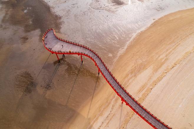 하늘에서 바라본 홍성 남당 노을 전망대의 모습. 너른 모래사장 중간에 빨간색 유선형 전망대를 조성했다 사진제공|한국관광공사