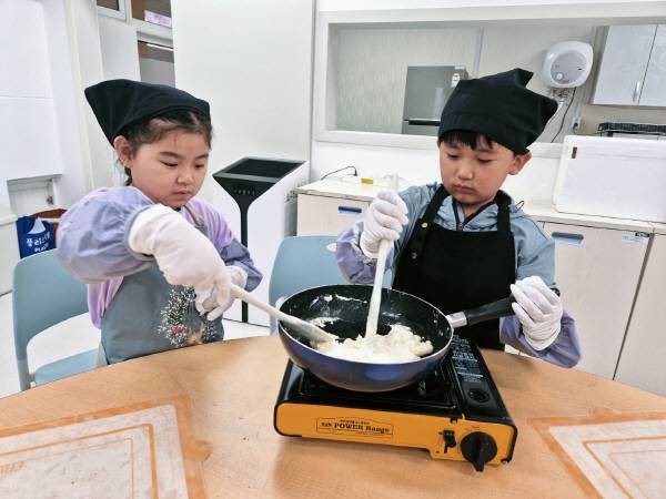 구천초등학교 저학년 학생들이 쿠킹 체험활동 중 반죽을 저으며 조리과정을 실습하고 있다. 의성교육청