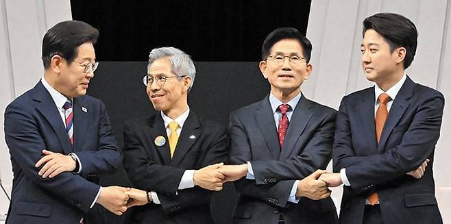 27일 서울 마포구 상암동 MBC 스튜디오에서 진행된 6·3 대선 정치 분야 TV 토론회에 앞서 대선 후보들이 서로의 손을 잡는 포즈를 취하고 있다. 왼쪽부터 이재명 더불어민주당 후보, 권영국 민주노동당 후보, 김문수 국민의힘 후보, 이준석 개혁신당 후보. /국회사진기자단